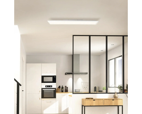 Helle Küche mit Deckenleuchte, Küchenschränken und Trennwand