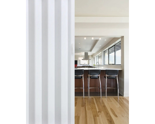 Blick durch eine Falttür in eine Küche mit Tresen und Barhockern