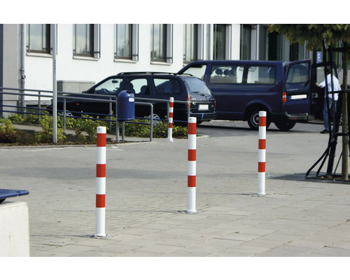 Absperrpfosten mit rot-weissen Streifen auf einem Parkplatz.