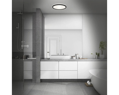 Badezimmer mit Dusche, Waschtisch, Badewanne und runder Deckenleuchte