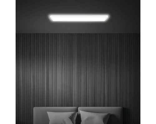 Beleuchtete Zimmerdecke mit LED-Deckenleuchte über Bett