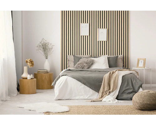 Helles Schlafzimmer mit Bett, Nachttischen und Holzpaneelen an der Wand