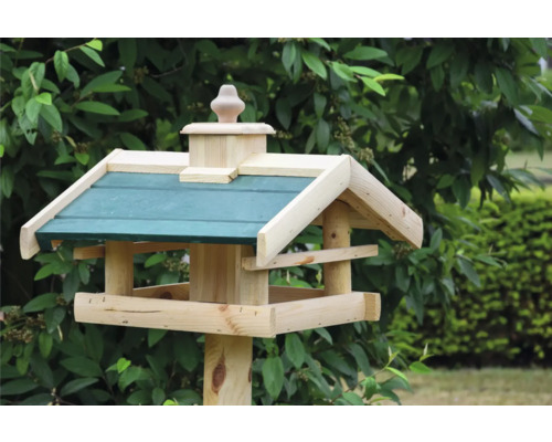 Vogelhaus aus Holz mit Dach auf einem Pfosten