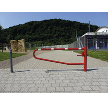 Eine rot-weiß gestreifte Schranke auf einem gepflasterten Weg in einem Außenbereich.