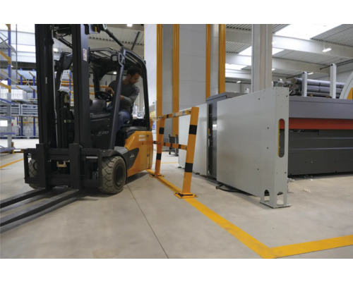 Gabelstapler fährt in einer Lagerhalle an einer Schutzvorrichtung vorbei