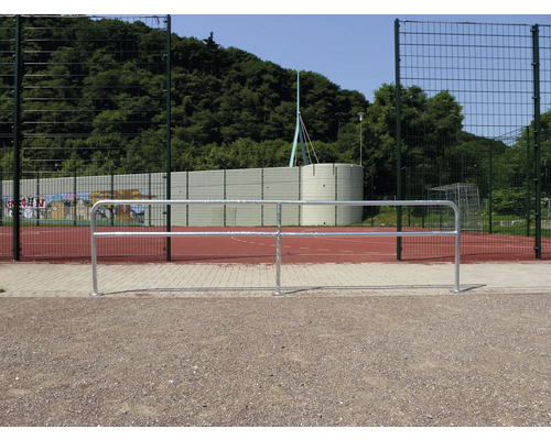 Außenaufnahme eines Bolzplatzes mit Ballfangzaun und Geländer.