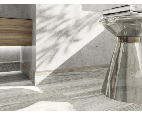 Detailaufnahme eines Interieurs mit einem Holzelement, einem transparenten Tisch und einem Buch