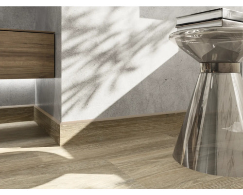 Detailaufnahme eines Interieurs mit Holzfußboden, Sockelleiste und einem Beistelltisch