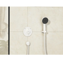 Duscharmatur mit Handbrause und rundem Thermostat an gefliester Wand