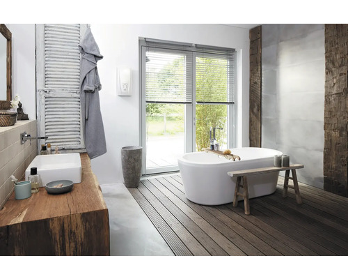 Helles Badezimmer mit freistehender Badewanne, Holzwaschtisch und Fenster mit Jalousien