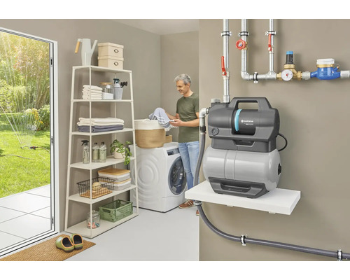Waschküche mit Waschmaschine, Regal, Hauswasserautomat und Person