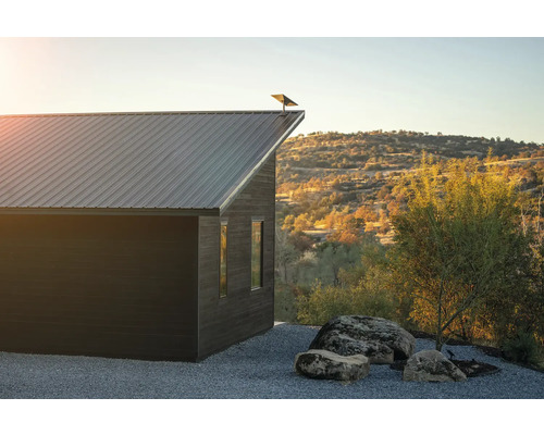 Modernes Haus mit Metalldach in ländlicher Umgebung.