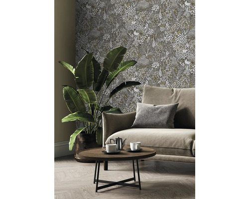 Wohnzimmer mit Couch, Tisch, Zimmerpflanze und gemusterter Tapete