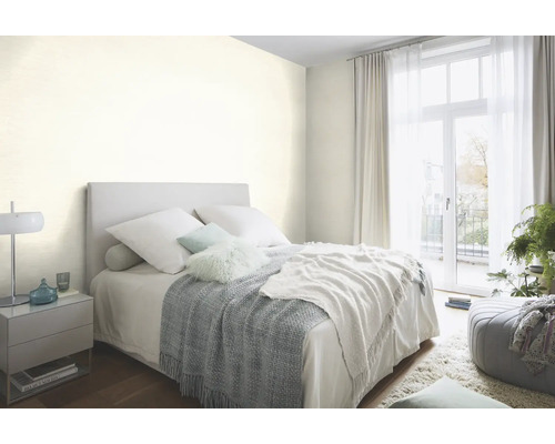 Helles Schlafzimmer mit Bett, Nachttisch und Tagesdecke