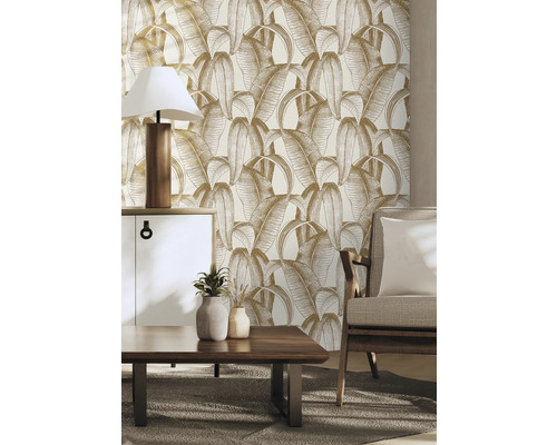 Wohnzimmer mit Blattmuster-Tapete, Kommode, Tischlampe, Couchtisch und Sessel