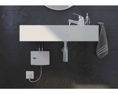 Waschbecken mit Armatur, Handtuch und Warmwasserbereiter im Badezimmer