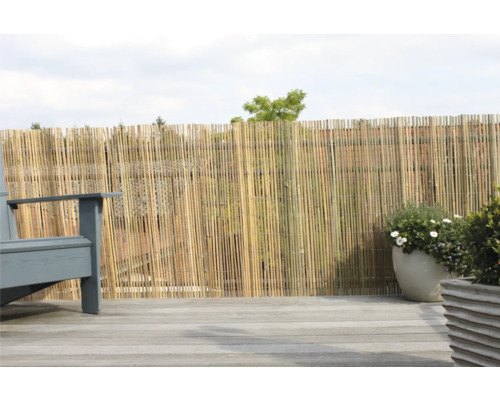 Bambus Sichtschutzzaun auf einer Terrasse mit Holzdeck, neben einem Stuhl und Topfpflanzen