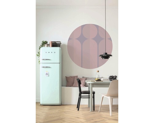 Essbereich mit Kühlschrank, Tisch, Stühlen und Wanddekoration.