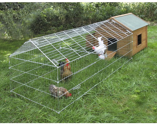 Hühnerstall mit Freilaufgehege und mehreren Hühnern auf einer Wiese.