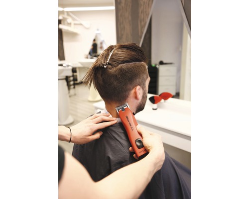 Friseur verwendet Haarschneidemaschine am Hinterkopf eines Mannes