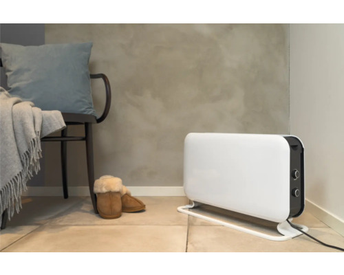 Szene mit einem Heizkörper, einem Stuhl mit Kissen und einer Decke sowie Hausschuhen