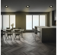 Innenaufnahme eines Essbereichs und einer Küche mit Tischen, Stühlen, Barhockern und Deckenleuchten