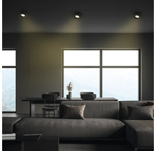 Wohnzimmer mit Sofa, Esstisch, Stühlen und Deckenleuchten