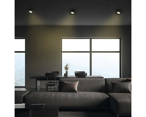 Wohnzimmer mit Sofa, Esstisch, Stühlen und Deckenleuchten