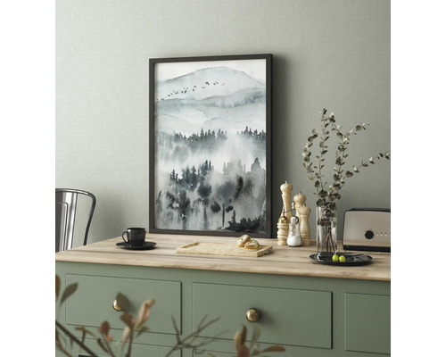 Gerahmtes Bild mit Aquarellmotiv einer Berglandschaft auf einem Tisch