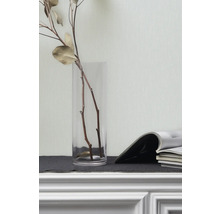 Dekorative Zweige in Glasvase und Zeitschriften auf einem Regal