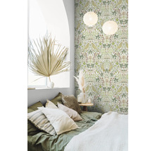 Schlafzimmer mit grüner Tapete mit Vogel- und Pflanzenmuster, Bett mit Kissen und dekorativen Elementen