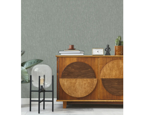 Wohnraum mit gemusterter Tapete, Sideboard und dekorativen Elementen.