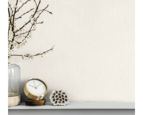 Dekorative Anordnung mit Vase, blühenden Zweigen, Tischuhr und getrockneter Lotusblume auf einem Regal.