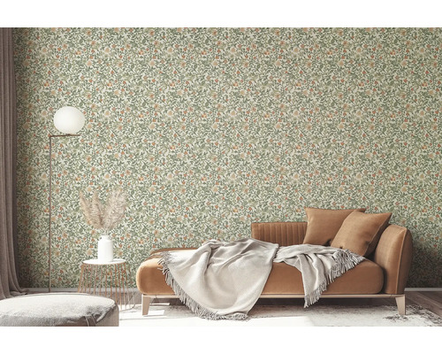 Wohnzimmer mit floral gemusterter Tapete, Sofa und Stehlampe.