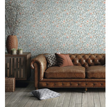 Wohnzimmer mit floral gemusterter Tapete, Ledersofa und Holzmöbeln für ein gemütliches Ambiente