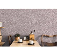 Wohnraum mit floral gemusterter Tapete und Holzesstisch