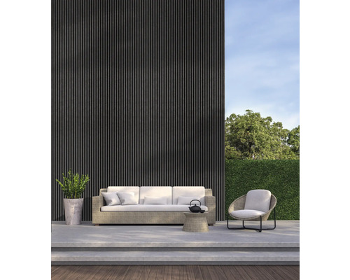 Terrasse mit Sofa, Sessel, Beistelltisch und Pflanze vor einer Fassade mit Lamellen