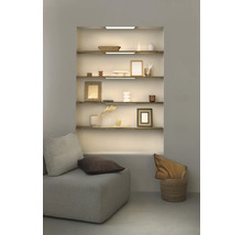 Regal mit Dekorationsgegenständen, beleuchtet mit LED-Leuchten, neben einem Sofa mit Kissen.