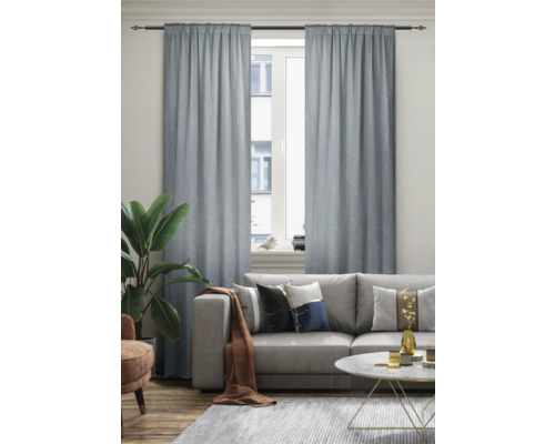 Wohnzimmer mit Sofa, Teppich und Vorhängen vor dem Fenster