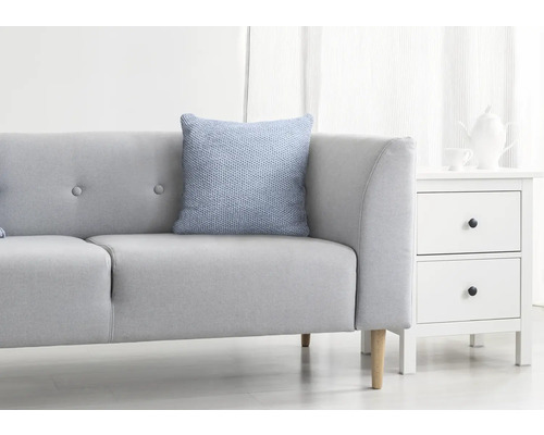 Helles Wohnzimmer mit grauem Sofa, blauem Kissen und weißem Nachttisch