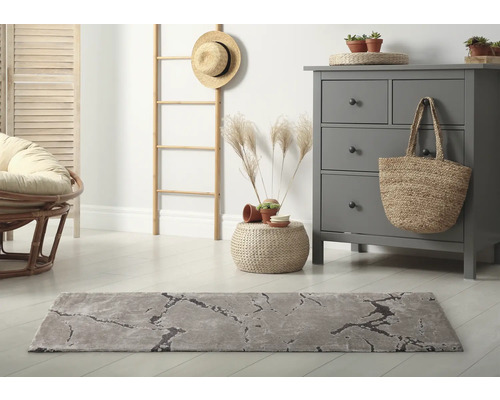 Wohnraum mit grauem Teppich, Kommode und Dekorationen