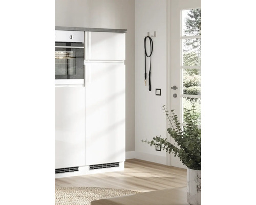 Küchenszene mit weißen Schränken, Backofen, schwarzer Hundeleine und Zimmerpflanze