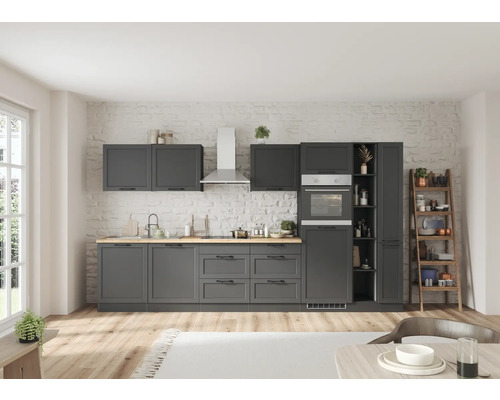 Graue Einbauküche mit Hängeschränken, Spüle, Herd und Backofen vor einer Ziegelwand