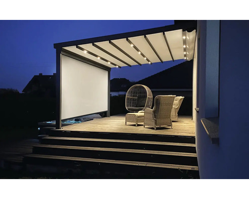Terrasse mit Pergola, Sitzmöbeln und Beleuchtung am Abend