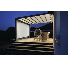 Beleuchtete Terrassenüberdachung mit Sichtschutzwand und Sitzgruppe auf einer Holzterrasse