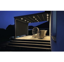 Beleuchtete Terrassenüberdachung mit Sitzgelegenheiten auf Holzterrasse bei Nacht