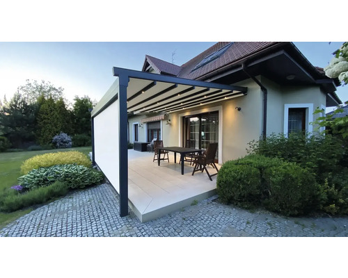 Terrasse mit Pergola, Sitzgruppe und seitlichem Windschutz am Wohnhaus