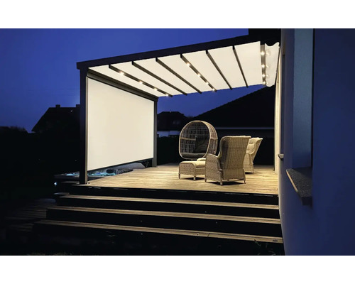 Beleuchtete Terrassenüberdachung mit Leinwand und Sitzmöbeln auf einer Holzterrasse