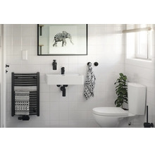 Helles Badezimmer mit Waschbecken, Handtuchwärmer und Toilette.