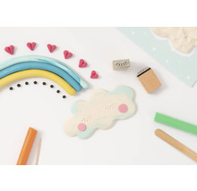 Szene mit Modelliermasse, die einen Regenbogen, Wolken, Herzen und Werkzeuge darstellt, die zum Erstellen von Modelliermassefiguren verwendet werden
